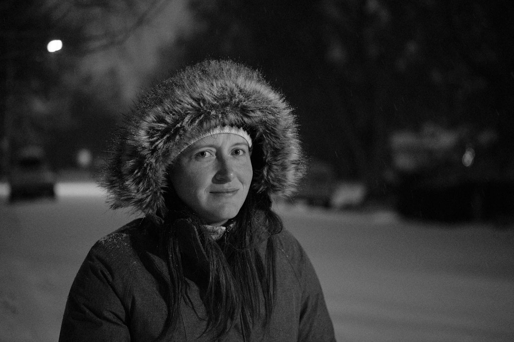 a portrait of Jean in a winter jacket lit by street lamps in the snow, high contrast monochrome