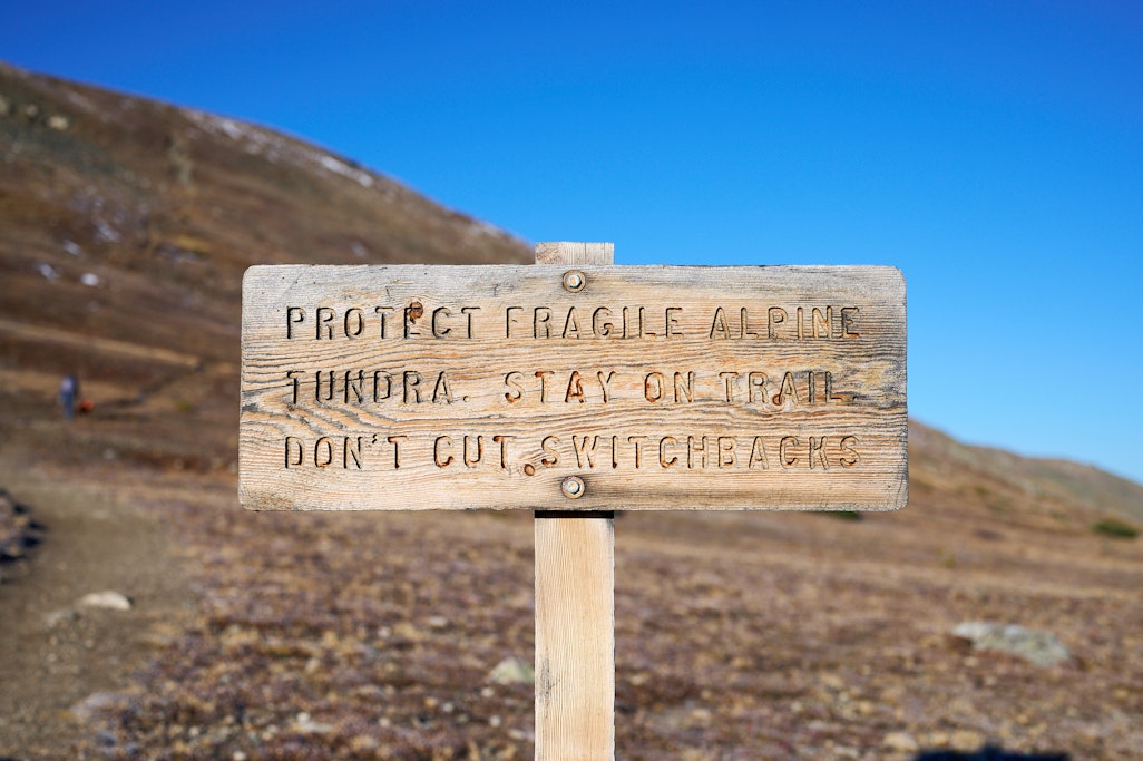 sign: PROTECT FRAGILE ALPINE TUNDRA. STAY ON TRAIL DON’T CUT SWIITCHBACKS