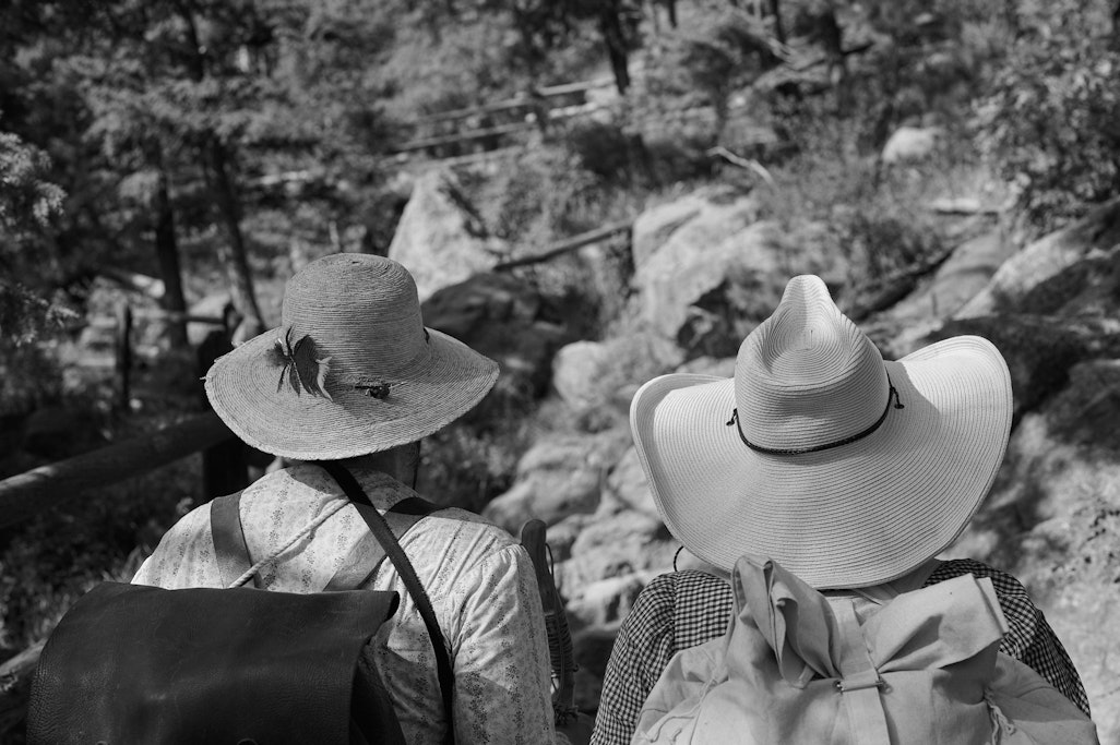view of two women’s hats in vintage replica clothing on Barr Trail near Colorado Springs, looking up the trail
