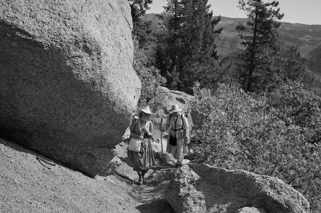 two women hiking in vintage early 20th century replica clothing on Barr Trail near Colorado Springs, monochrome
