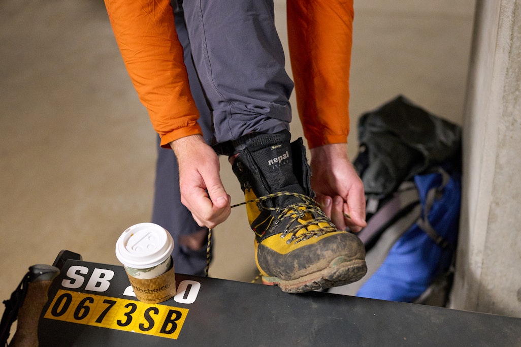 tying mountaineering boots before a hike