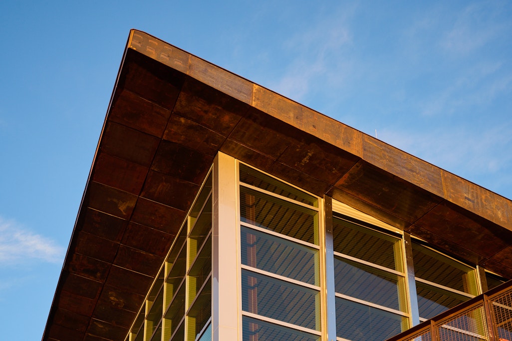 detail of the window and roof from the outside of the angular summit house, lit by the glow of sunrise