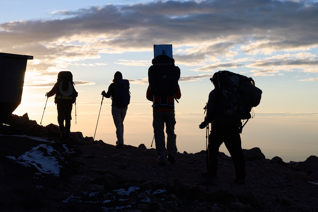 silhouettes of volunteers on the summit at sunrise