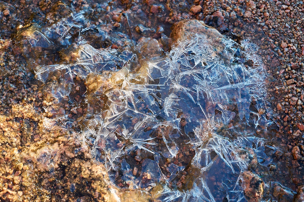 melting ice on a rocky Barr Trail above tree line after sunrise