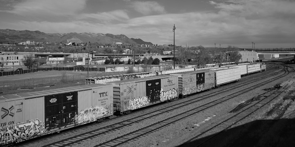 trains on the track in downtown Colorado Springs, wide scene with mountains in the distance