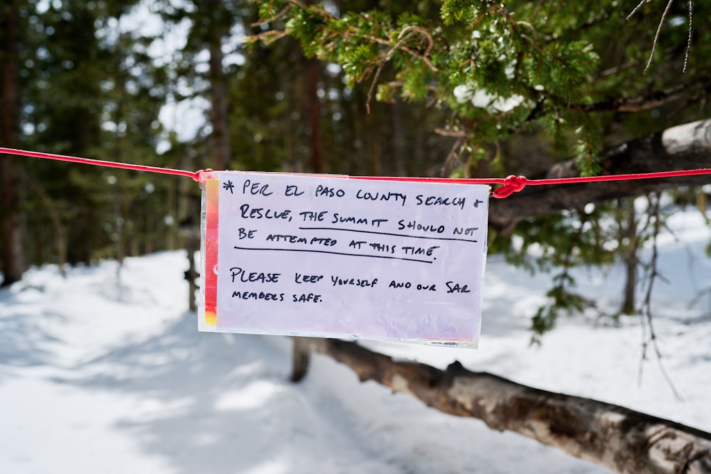 a handwritten sign across Barr Trail by El Paso County Search and Rescue advising that hikers should not attempt a summit attempt of Pikes Peak in the snow