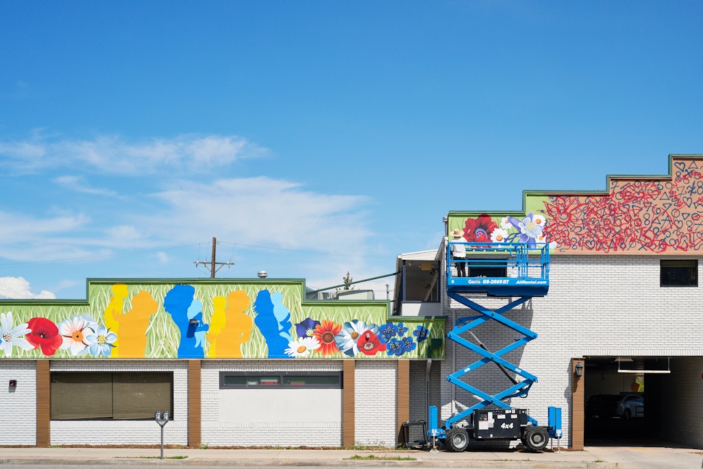 wide view of a mural in progress in downtown Colorado Springs by Molly McClure, from across the street