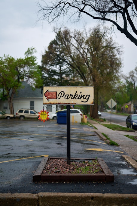 a hand-painted red and cream Parking sign in an empty lot