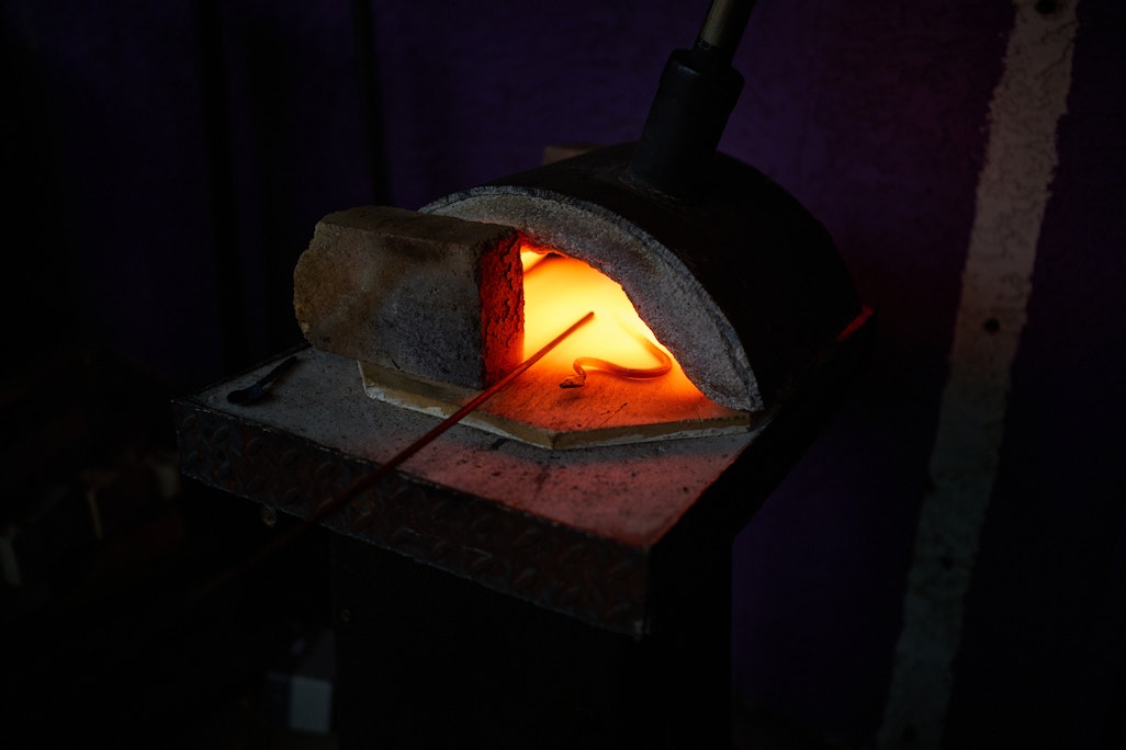 molten iron in a dark gray oven, glowing bright orange