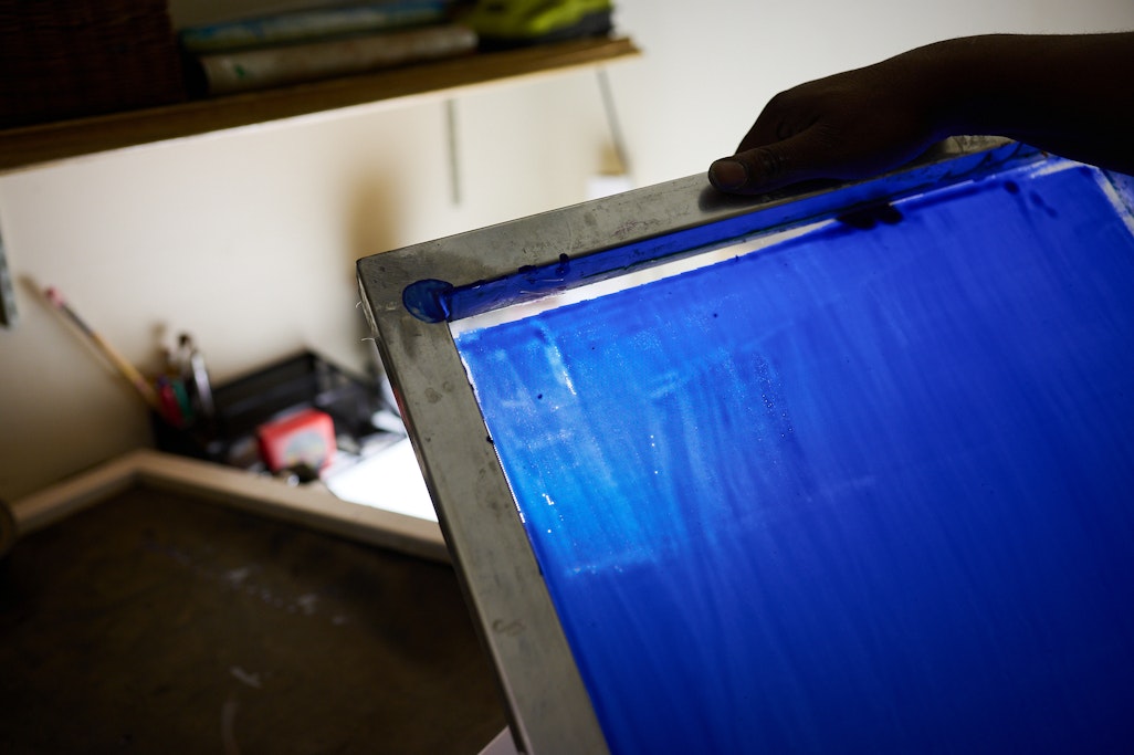 the mesh grid of a blue screen printing frame, lit up in a dark room