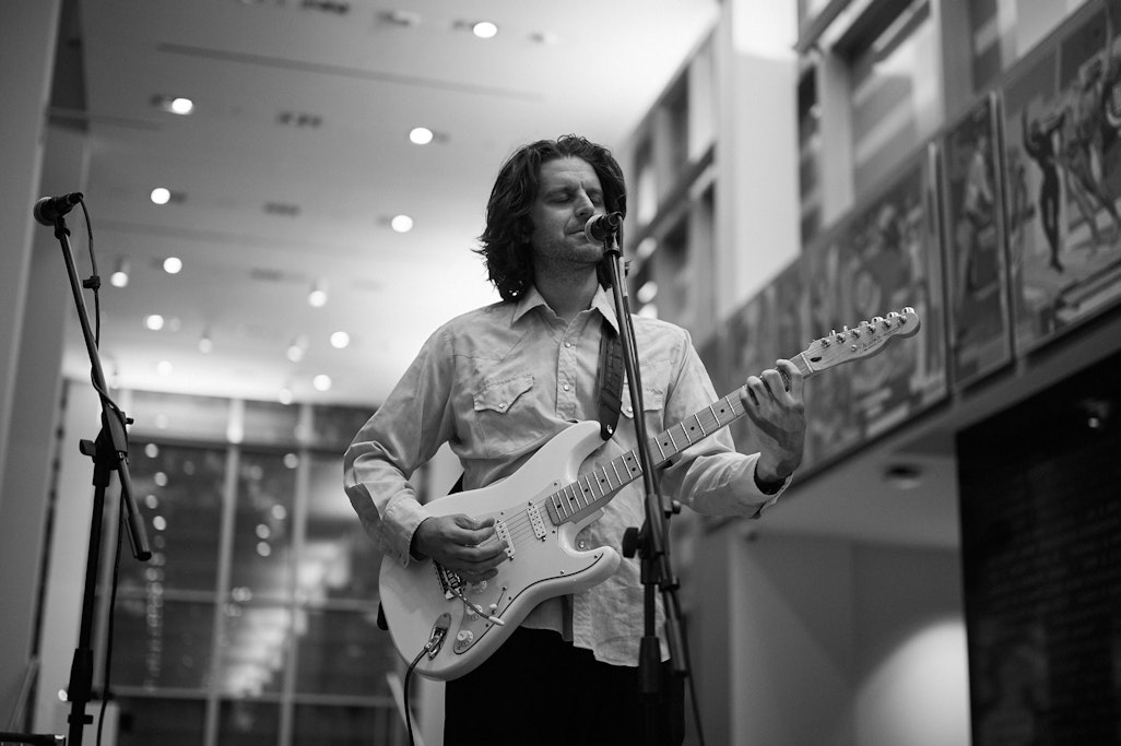 Bryan Sespico, playing guitar at a Fine Arts Center event by Gray Duck