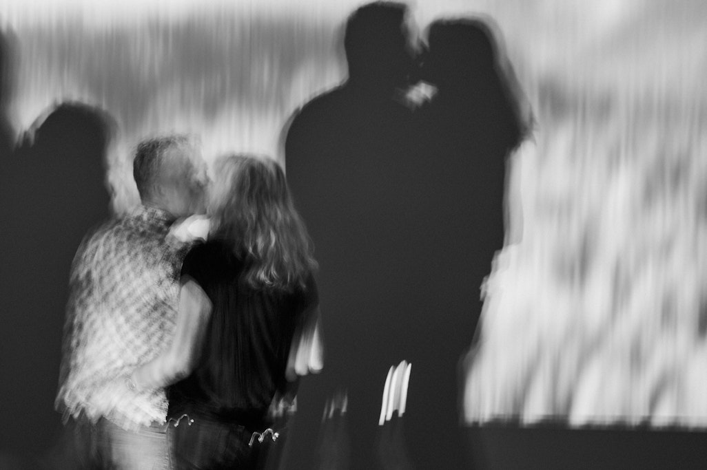 two people kissing, sillhouetted by the light of a projector, at Fine Arts Center